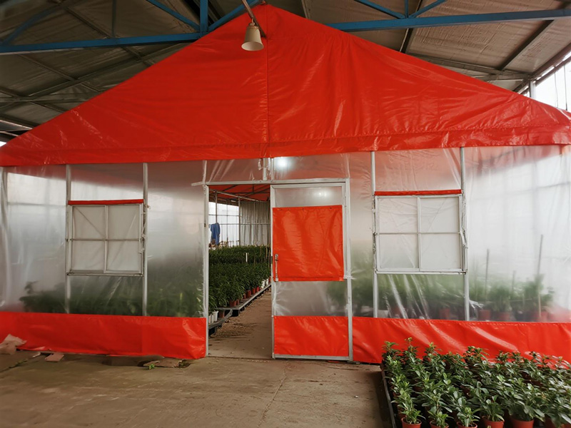 PVC insulation tarp covering flower seedlings in nursery trays, creating optimal growing environment