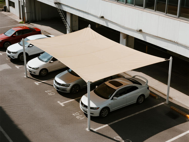Parking lot shade structure with PVC fabric covering multiple car spaces, protecting vehicles from sun exposure