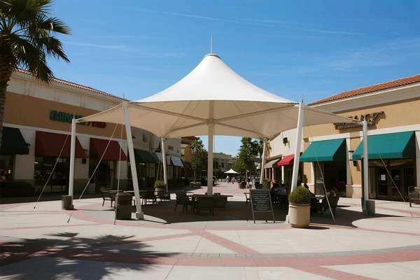 Shopping mall plaza with large shade structure covering outdoor dining and gathering areas