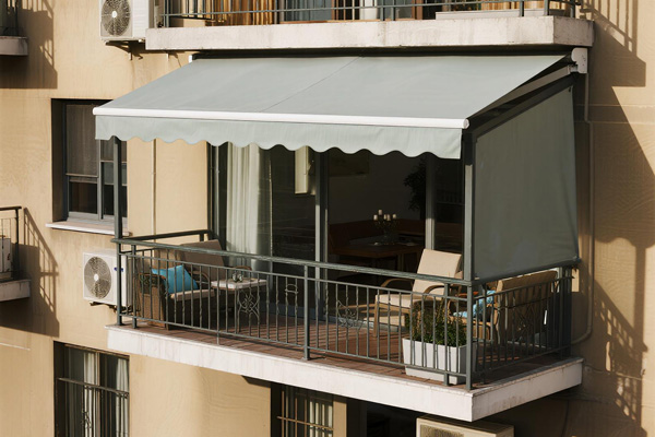 Apartment balcony with plants and seating protected by rain curtains