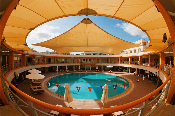 Hotel resort pool with retractable rain covers for guest comfort