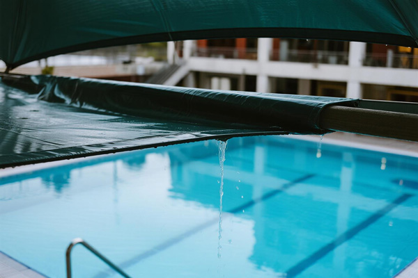 Public swimming pool with rain covers protecting equipment and deck areas