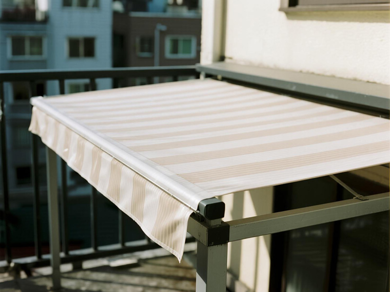 Apartment balcony with insulation rain cover installed, showing heat reflection and rain protection