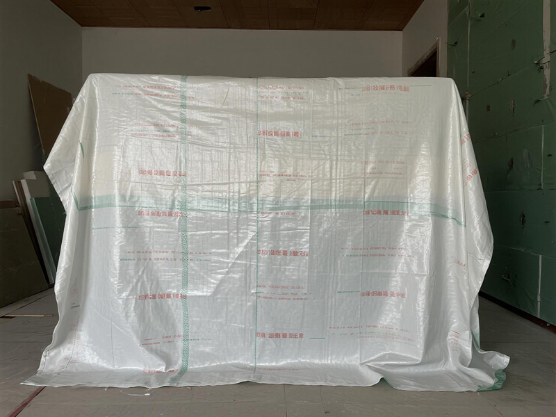 Close-up showing paint splatters on cover, protecting underlying furniture