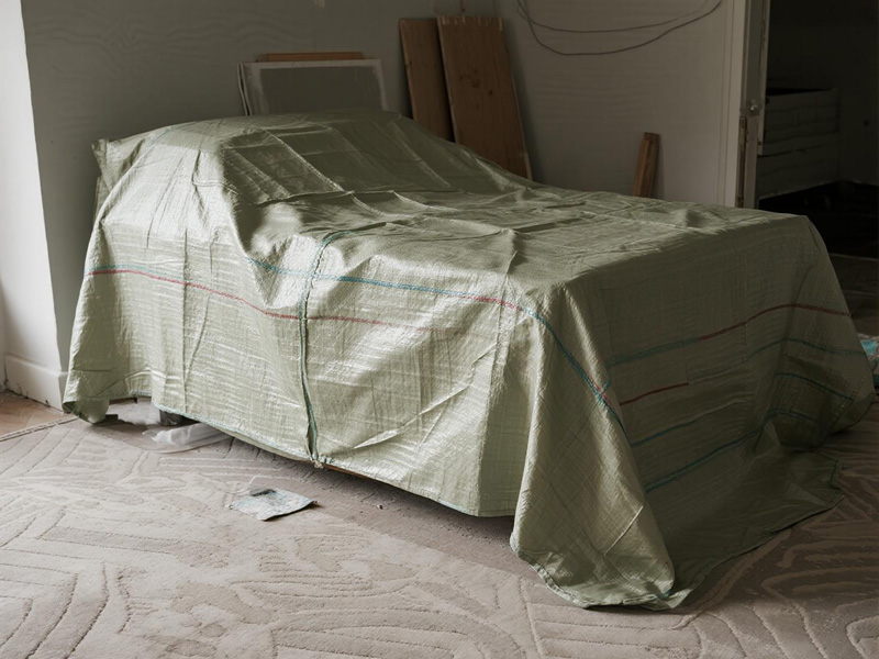 Furniture cover secured with tape to prevent dust infiltration