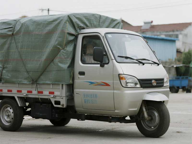 Tricycle with goods protected by tarpaulin