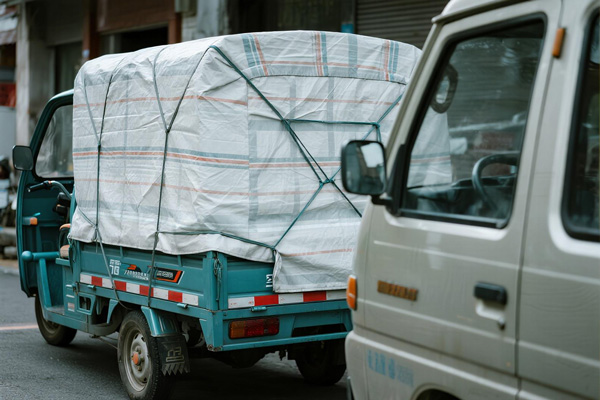 Small truck and三轮车tarps protecting cargo during transportation