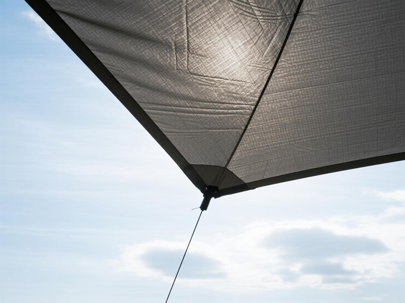 Portable sun shade tarp set up at campsite providing shelter from sun