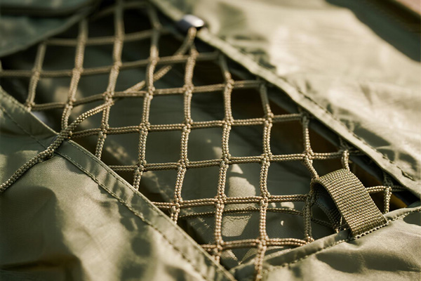 Waterproof storage tarp covering camping gear at campsite during rain