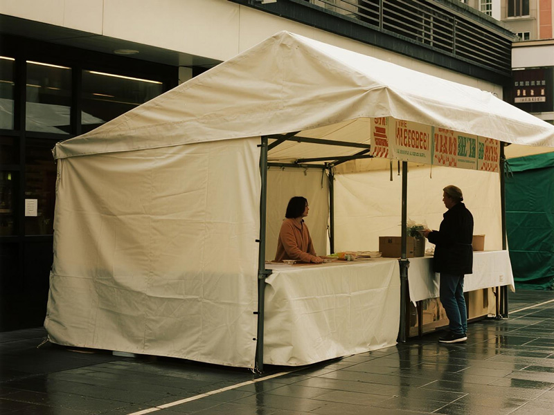 Market stall covered with waterproof tarp protecting merchandise during rain
