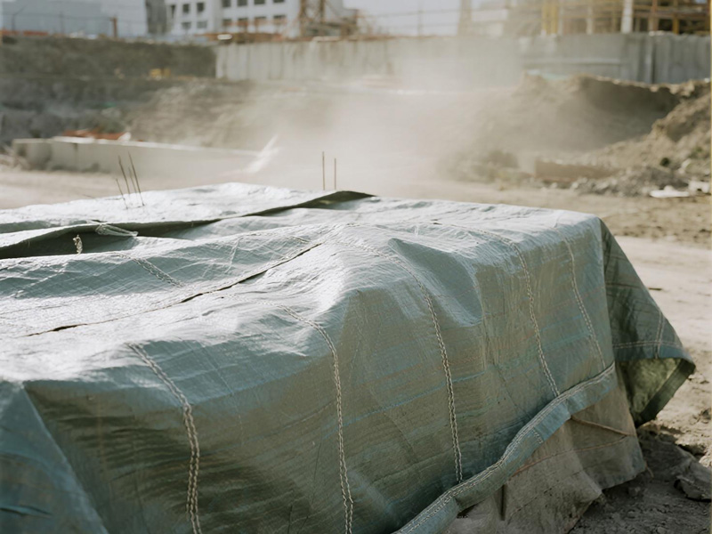 Tarp protecting cement bags during rain