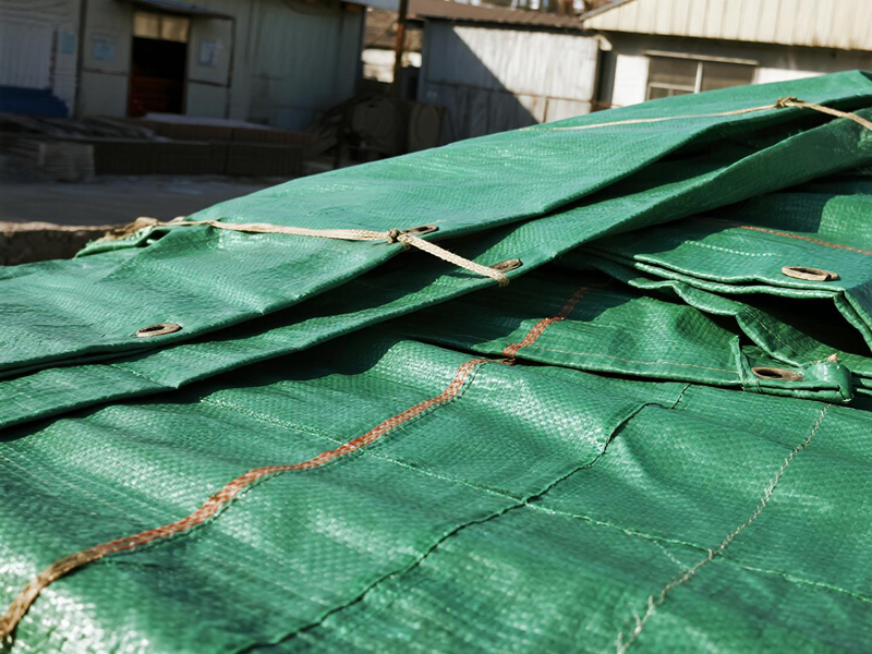 Construction material tarp showing secure anchoring and industrial design features