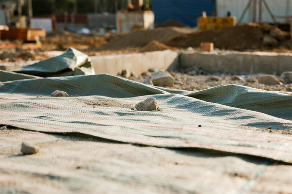 Gravel and sand piles covered with protective tarp