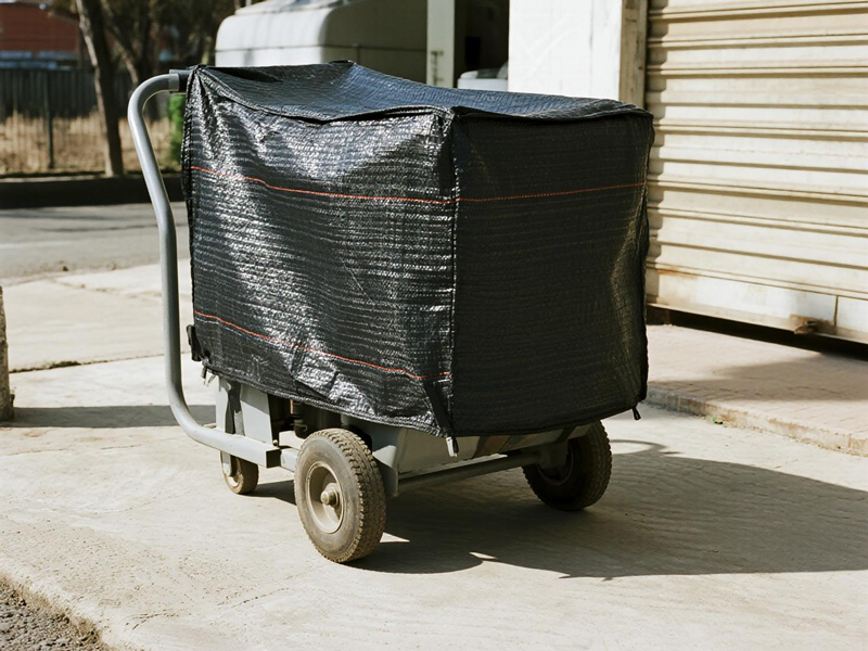 Cutting machine covered with dust cover in workshop environment
