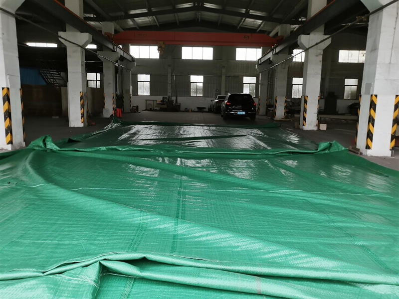 Workers deploying emergency tarp in warehouse
