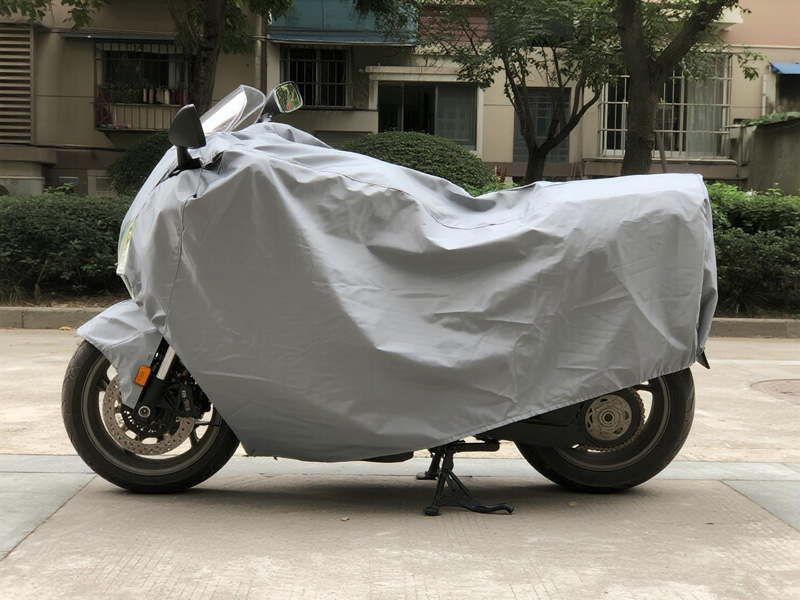 Motorcycle protected with Oxford fabric cover in outdoor setting
