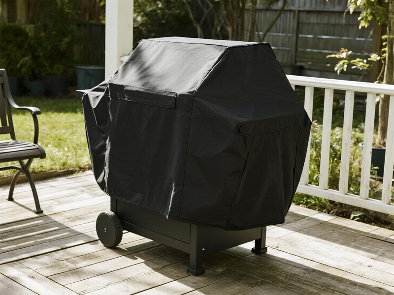 Outdoor grill protected with Oxford fabric cover on patio