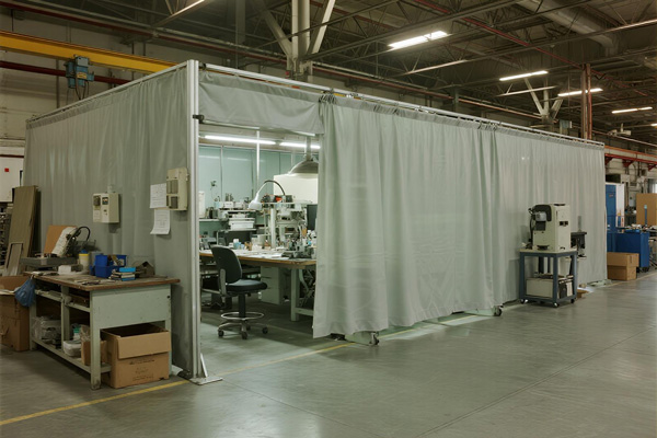 Manufacturing facility with partition curtains creating work zones