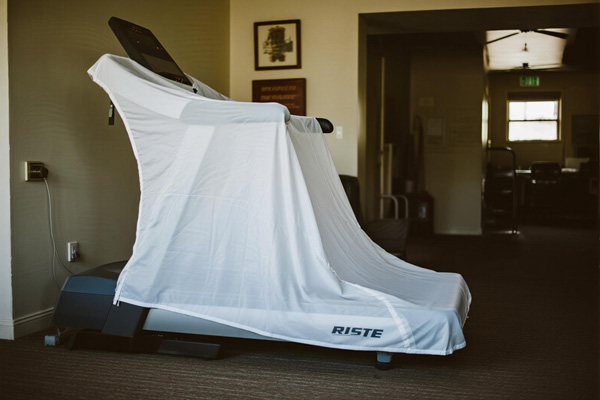 Treadmill covered with protective polyester cover in home gym
