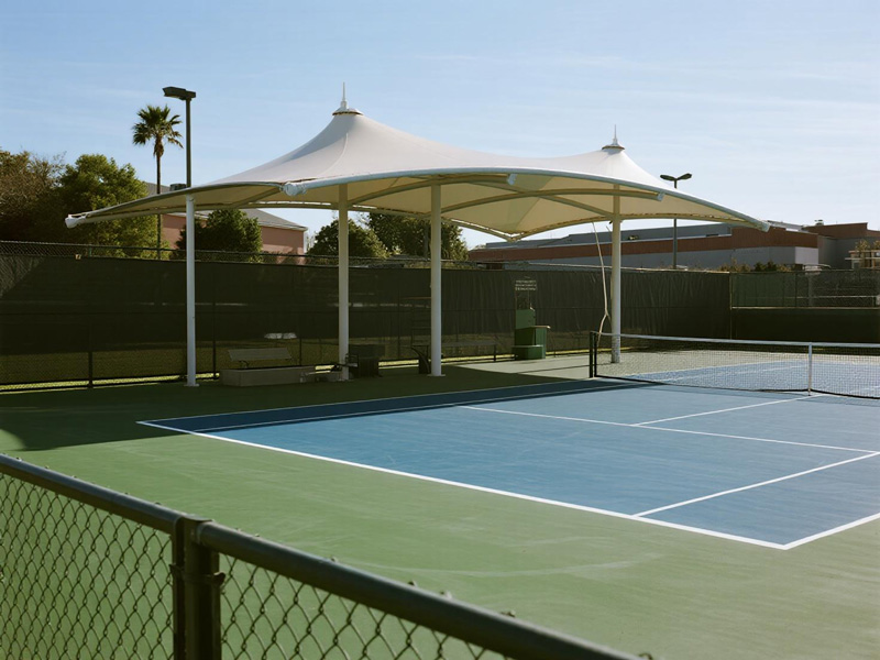 Polyester shade structure covering tennis court with players