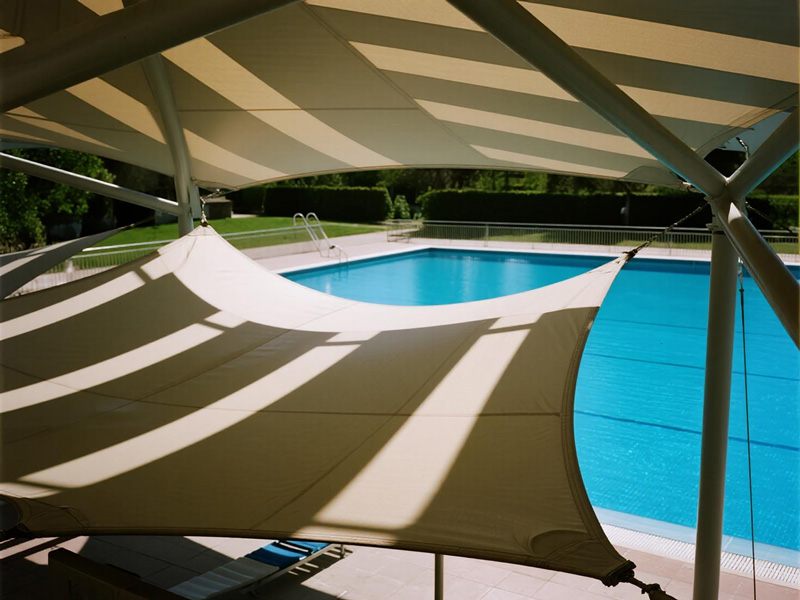 Poolside area with polyester shade sail installation