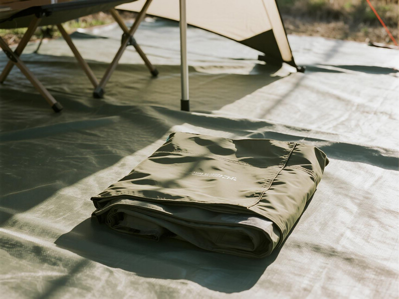 Close-up of durable polyester camping tarp showing waterproof coating and reinforced edges