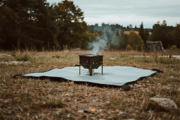 Portable BBQ setup with mat on camping ground