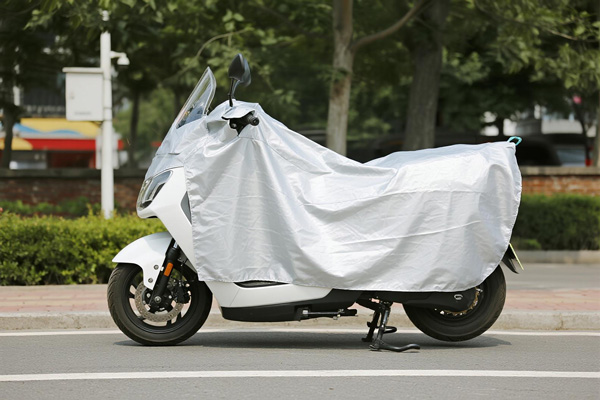 Motorcycle covered with protective cover in driveway