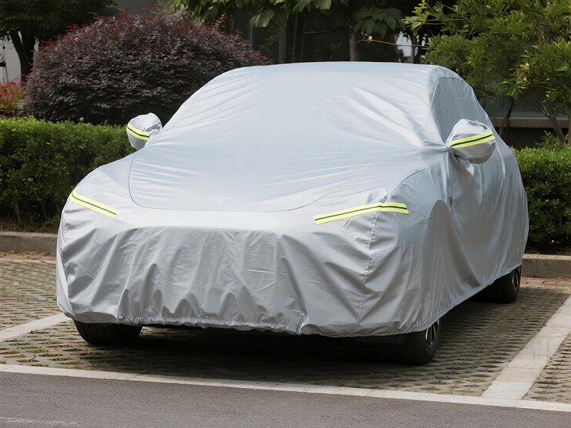 SUV covered with protective car cover in driveway