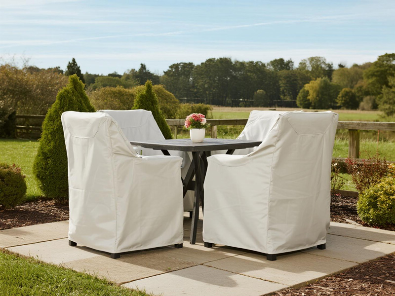 Patio furniture set protected by waterproof covers in garden setting
