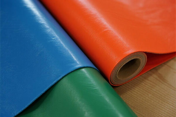 Side-by-side display of a white, smooth food grade PVC fabric and a rugged, heavy-duty industrial grade PVC fabric.